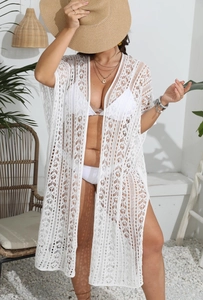 Détail de la maille crochetée blanche sur ce cardigan de plage long et ajouré
