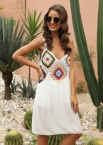 Détail de motifs floraux crochetés à la main sur une robe de plage bohème blanche