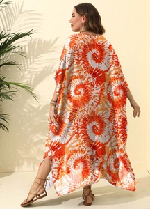 Detail of loose printed beach cover-up dress showing vibrant orange floral tie-dye texture