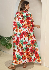 Detail of vibrant floral print kaftan dress with tropical leaves for beach vacation style