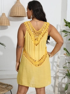 Macro detail of vibrant yellow crochet backless beach dress with intricate bohemian lacework