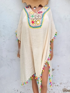 Close-up of bohemian crochet beach cover-up with floral neckline and multicolor tassels