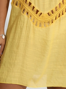 Detail of yellow crochet neckline and fringe on bohemian beach cover-up dress