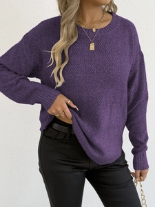 Detail of dark purple knit sweater texture with layered gold necklaces and round neckline