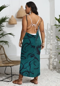 Detail of bohemian backless maxi dress with thin white tie straps and dark green print