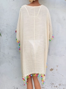 Detailed back view of a beige crochet beach cover-up dress featuring colorful fringe tassels