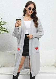 Detail of red heart patch embroidery on a grey knit oversized cardigan pocket
