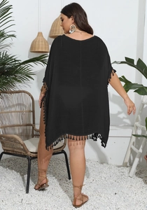 Rear view of black oversized beach cover-up featuring delicate fringe tassels on the hemline