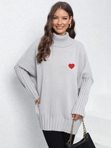 Loose fit light grey turtleneck sweater with a red heart patch and outdoor styling