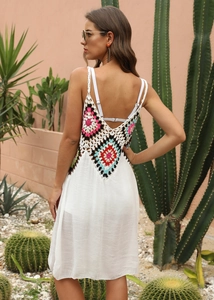 Détail du patchwork en crochet coloré sur robe de plage blanche bohème dos nu