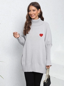 Close-up of gray turtleneck knit sweater with red heart embroidery on the chest