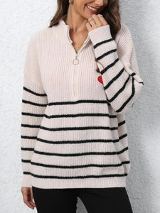 Detail of striped knit sweater with silver zipper collar and red heart embroidery
