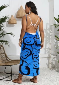 Detail of blue backless maxi beach dress with black swirl print and white thin straps