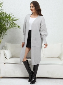 Detailed texture of light gray knit cardigan featuring ribbed cuffs and front pockets