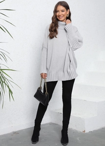 Detail of grey oversized high-neck knitted sweater with ribbed texture and loose fit