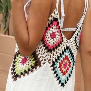 Détail de la robe de plage en crochet blanc avec des motifs floraux colorés au dos