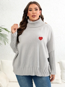 Close-up of grey turtleneck sweater featuring a red embroidered heart and knit texture