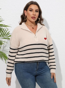 Détail d'un pull rayé grande taille avec col demi-zip et écusson en cœur rouge