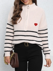 Detail of knit sweater with half-zip collar, red heart embroidery and black stripes