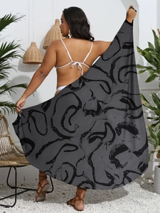 Close-up of lightweight oversized sarong with abstract spiral print on beach background