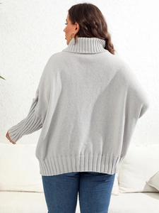 Close-up of oversized grey high collar knit sweater with ribbing detail on the cuffs