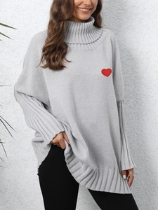 Detailed view of red heart embroidery on a grey turtleneck loose knit sweater top