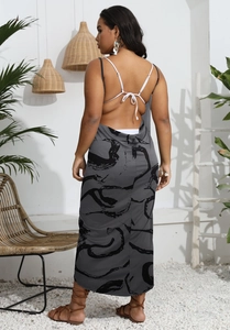 Detail of grey backless beach dress with black abstract print and thin crossover straps