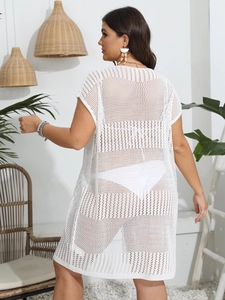 Detail of white knit hollow-out beach cover-up showing crochet texture and loose fit
