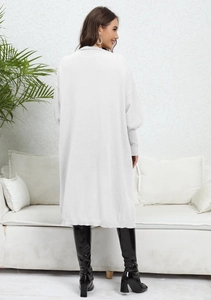 Back view of a thick white knit cardigan with lantern sleeves and textured knit pattern