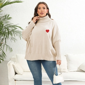 Detail of red heart embroidery patch on beige high neck oversized knitted sweater