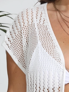 Detailed close-up of white crochet beach cover-up featuring intricate openwork knit texture