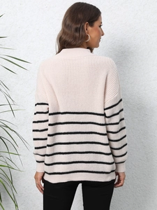 Detail of loose knit sweater with horizontal black stripes and dropped shoulder design