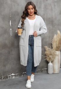 Détail du cardigan en maille gris clair avec texture gaufrée et grandes poches latérales