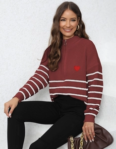 Detail of burgundy knit sweater with half-zip collar and white stripes on the sleeves