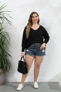 Detail of V-neckline with delicate black lace trim on women's plus size knit sweater
