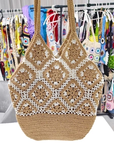 Detail of handmade crochet tote bag with light brown granny square patterns and white edges