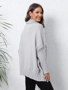 Detailed back view of a loose light grey turtleneck knit sweater with ribbed cuffs