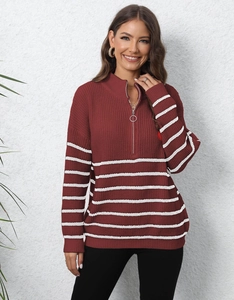 Detailed knit texture of burgundy half-zip sweater with white striped hem and ring puller