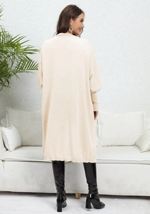 Close-up of long-sleeved chunky knit cardigan showing the warm cream texture and loose fit