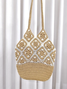 Detailed close-up of handmade crochet tote bag with khaki and white floral patterns