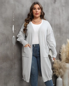Gros plan sur un long cardigan gris clair avec poches plaquées et poignets côtelés
