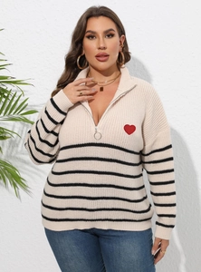 Détail du patch cœur rouge sur un pull rayé beige avec col à demi-fermeture