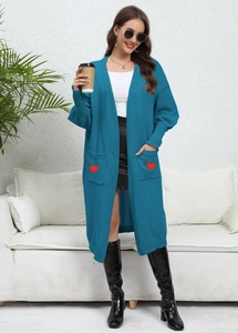 Detail of teal knit cardigan featuring large pockets with vibrant red heart embroidery