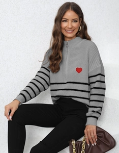 Detail of grey half-zip sweater featuring shoulder stripes and red heart embroidery