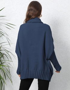 Detail of navy blue turtleneck knit sweater featuring wide ribbed cuffs and hemline
