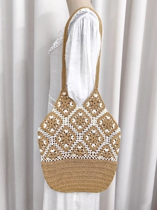 Detail of bohemian handmade crochet tote bag featuring brown floral openwork patterns