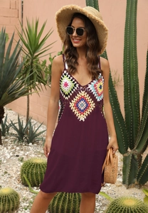 Détail du corsage en crochet bohème aux motifs géométriques colorés sur une robe de plage
