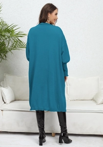 Rear view of a loose knit peacock blue long cardigan sweater with ribbed sleeve cuffs