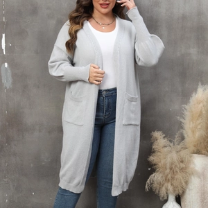 Détail d'un long gilet gris en maille avec poches fonctionnelles et manches lanternes