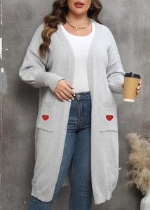Detail shot of the red embroidered heart on the front pocket of a grey knitted cardigan